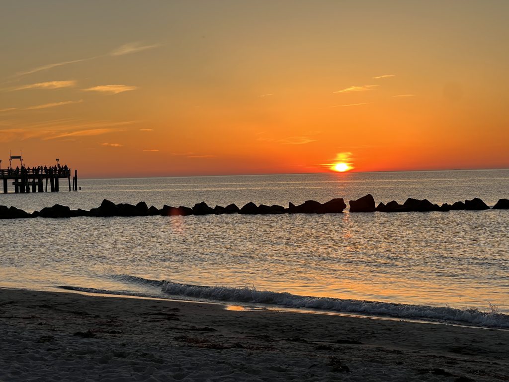 Sonnenuntergang am Ostseestrand von Wustrow mit Seebrücke und Buhnen